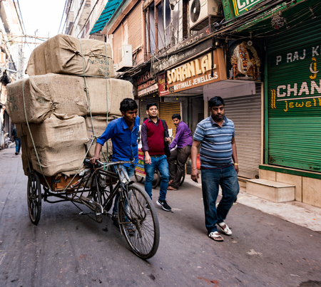New Delhi, India, Feb 20, 2018 - Man carries large load of grain upon his bicycleのeditorial素材