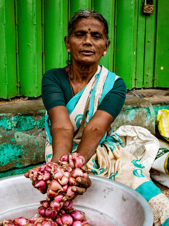 Madurai, India, Mar 8, 2018 - Woman shows the onions she is sellingのeditorial素材