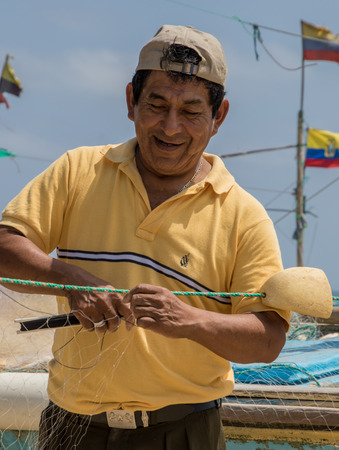 Puerto Lopez, Ecuador - Aug 19, 2016: Fisherman repairs his netのeditorial素材
