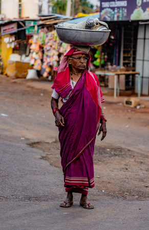 BADAMI, INDIA, MAR 18, 2018: Woman carries her load on her headのeditorial素材