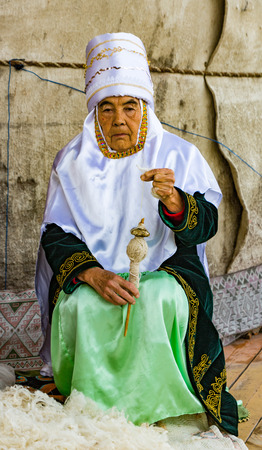 Almaty, Kazakhstan - May 31, 2017: Woman spins wool yarnのeditorial素材