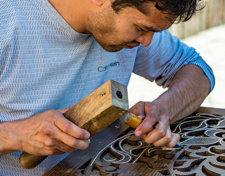 Tashkent, Uzbekistan - May 18, 2017: Man chisels wood engraving in workshop near Chorsu Bazaarのeditorial素材