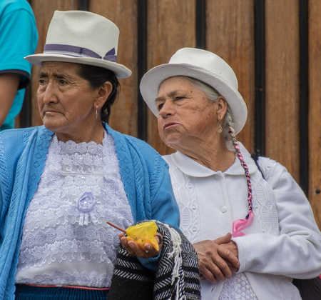 Cuenca, Ecuador - Nov 3, 2016: Two elderly women watch passing parade with interestのeditorial素材