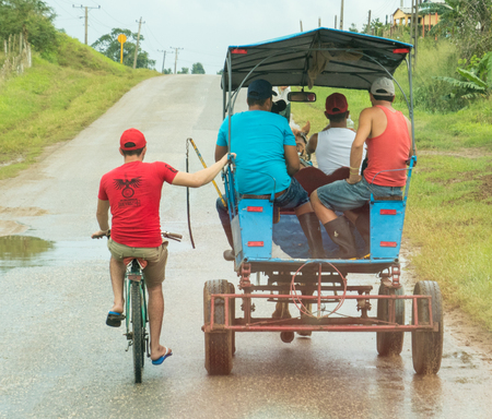 Trinidad, Cuba, Nov 26, 2017 - Man on bicycle hitches ride on horse-drawn cartのeditorial素材