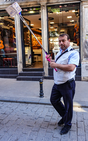 Ortakoy, Turkey / April 30, 2016 - Street vendor walks the street selling selfie sticksのeditorial素材