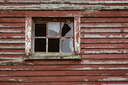 Weathered red paint and broken windows are a common site on barns in Vermontの写真素材