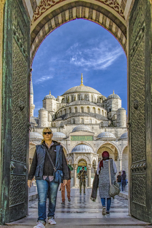 Istanbul, Turkey / April 1, 2016 - Woman walks out through doors of the Blue Mosqueのeditorial素材