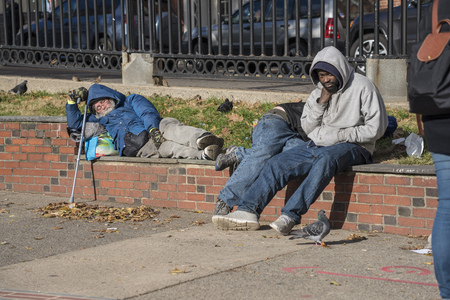 Boston, Massachusetts - October 25, 2018 - Homeless man sleeps on a brick wall in a parkのeditorial素材
