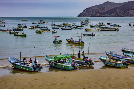 Puerto Lopez, Ecuador - September 12, 2018 - Fishermen finish their day fixing nets, cleaning boats, and talking with friendsのeditorial素材