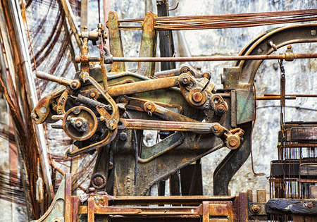 Old printing press stored outside, causing it to rust away