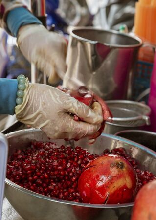 Vendor Extracts Pomegranate Seeds To Make Juice.の写真素材