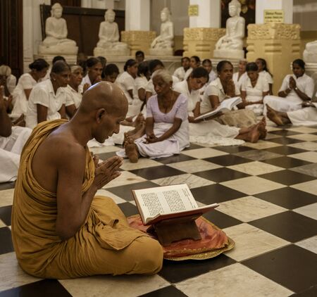 Kandy, Sri Lanka - 09-03-24 - Monk Leads Worshippers in Prayer in Temple.のeditorial素材