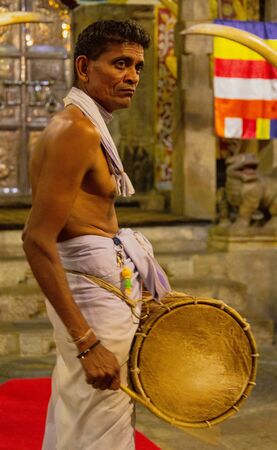 Kandy, Sri Lanka - 09-03-24 - Lay Priest Plays Drum in Hindu Temple.のeditorial素材