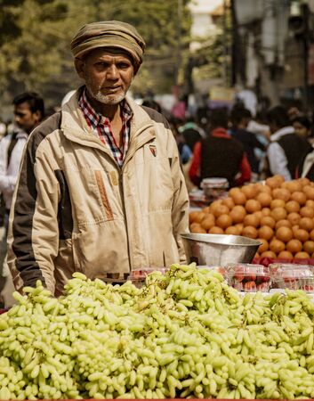 New Dehli, India, Feb 19, 2018: Man sells grapes in street cart in Indiaのeditorial素材