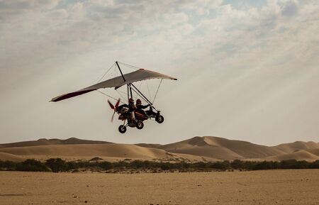 Walvis Bay, Namibia - July 16, 2018: An ultralight aircraft takes off from an improved dirt runway in Namibiaのeditorial素材