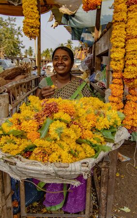 BADAMI, INDIA, MAR 18, 2018: Smiling woman sells flowers from her stallのeditorial素材