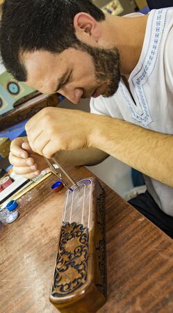 Tashkent, Uzbekistan - May 18, 2017 - Artisan creates fine art with wood using chiselのeditorial素材