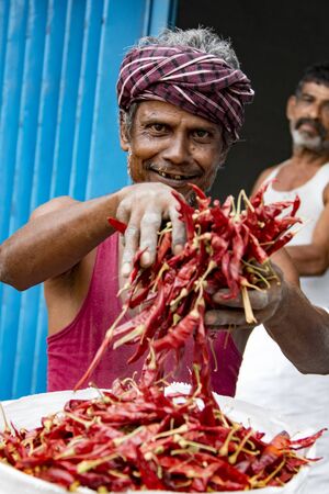 Tashkent, Uzbekistan - May 18, 2017: A vendor proudly shows off his bag of red jalepeno in Indiaのeditorial素材