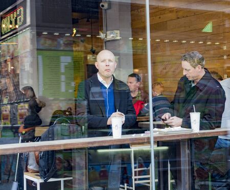 New York, Feb 14, 2018 - People eating at indoor cafe seen through window from streetのeditorial素材