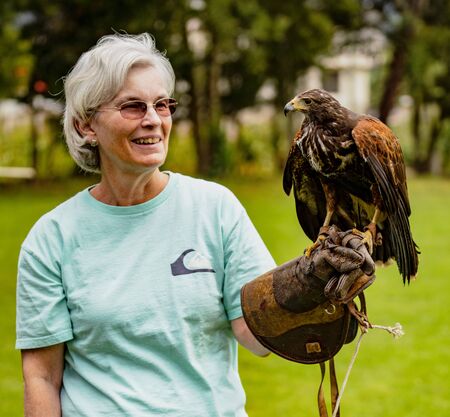 Gualaceo, Ecuador - June 1, 2018: A woman holds a bird of prey at an ecological rescue center in Ecuadorのeditorial素材