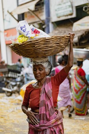 Mannar, India, Mar 8, 2018 - Woman carries her load on her headのeditorial素材