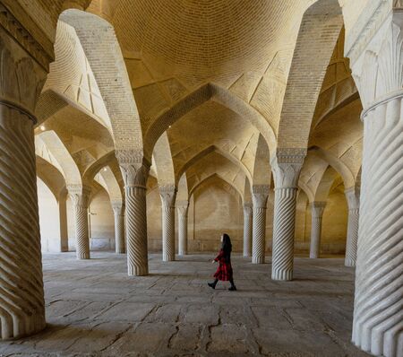 Shiraz, Iran - 2019-04-08 - Woman walks through fluted columns of Vakil Mosque.のeditorial素材