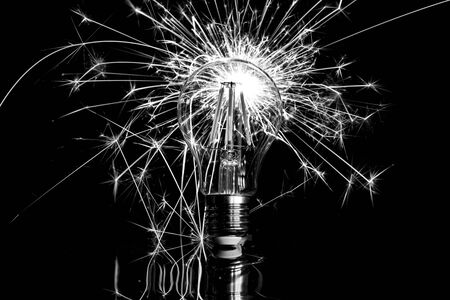 Fireworks sparkler behind LED light bulb - black  whiteの写真素材