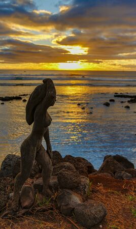 Easter Island, Chile - 2019-07-11 - Wood carved statue on the beach at sunset.のeditorial素材