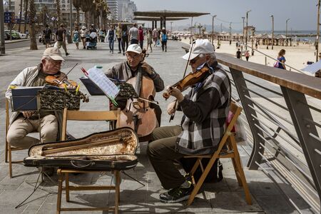 Tel Aviv, Israel - 2019-04-27 - String trio composed of elderly men play on the beach boardwalk.のeditorial素材