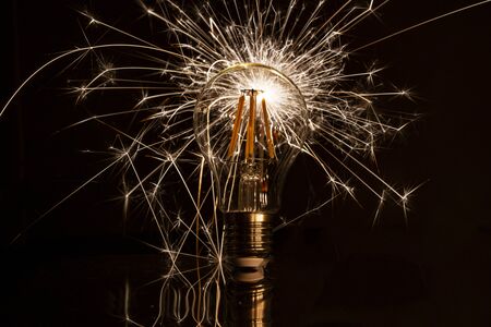 Fireworks sparkler behind LED light bulb burnsの写真素材