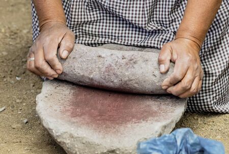 Woman shows how to grind insects to create a natural permanent red dye.の写真素材