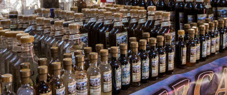 Oaxaca, Mexico - 2019-11-30 - Mezcal is lined up in liquor booth in market.のeditorial素材