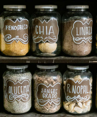 Jars on a store shelf labled with various spices.のeditorial素材