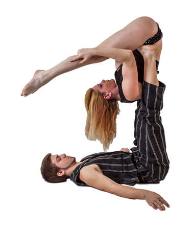 Young couple practices acrobatic balance with woman in V position on man s upstretched legs.のeditorial素材