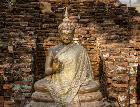 Sitting Stone Buddha in an Ancient Brick Alcove.の写真素材