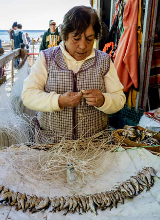 Valparaiso, Chile - 2019-07-30 - Woman threads hooks on fishing leader lines.のeditorial素材