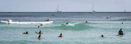 Honolulu, Hawaii - Nov 6, 2021-Young boys play on their boogey boards in the surf.