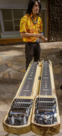 Waikiki, Honolulu, Hawaii - Nov 6, 2021-Man stands next to his steel guitar as street entertainment.のeditorial素材