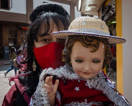 cuenca, Ecuador, Dec 24, 2021 - Woman holds baby Jesus doll in the traditional Traveling Child Pase del Nino Christmas Eve Parade.のeditorial素材