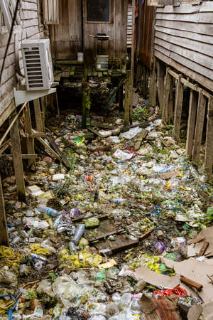 Central Kalamantan, Indonesia; May 20, 2022 - Garbage is dumped between homes along the river bank.の写真素材