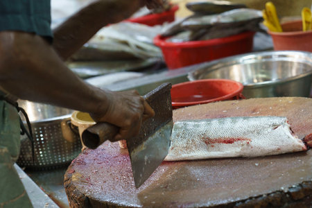 Malaysia, July 10, 2022 - Fish is cut up at market by vendor in Malacca.