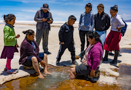 Uyuni, Bolivia, 01182023 - Women soak their feet in the mineral water of the Bolivian Salt Flats.のeditorial素材