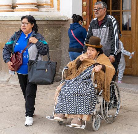Copacabana, Bolivia, 01172023 - Old woman in wheelchair is taken outside a nearby church.のeditorial素材