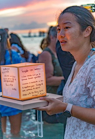 hawaii, honolulu - 20230530: Shinnyo Floating Lantern Festival - people carry their personal lantern to the ocean with wishes written for their dear departed dead.のeditorial素材