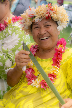 Honolulu, Hawaii/USA - 2022-08-20 - Shaka Filming Hukilau - smiling woman shows off a strip from a banana leaf that she will use in making a hat.のeditorial素材