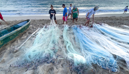 Honolulu, Hawaii/USA - 2022-08-20 - Shaka Filming Hukilau - participants arrange fishing nets in prepartion for throwing into ocean.のeditorial素材