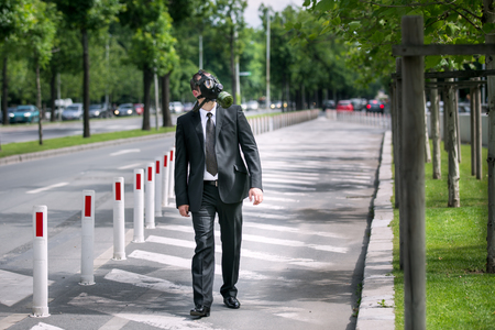 Businessman wearing a gas mask looking to the skyの写真素材
