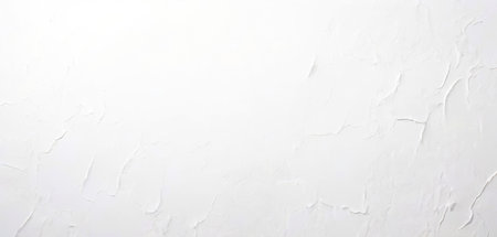 Softly lit white marble wall, emphasizing its smooth and refined texture.