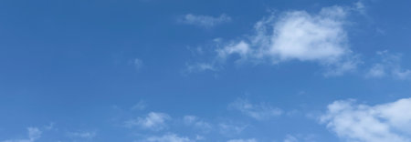 Daytime sky with fluffy clouds and clear blue backdrop. Premium beautiful cloud photography with perfect height, Background for banners, and website posters.の写真素材