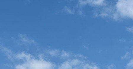 A clear blue sky with light cloud formations. Modern photo with blue light during the day,...